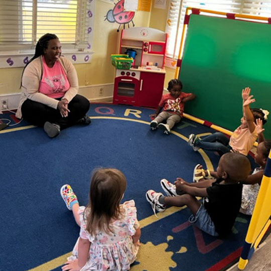 Small children raising their hands.